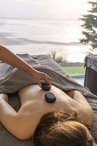Saunton Sands Hotel Source Spa Guest Receiving Hot Stone Massage in Treatment Room