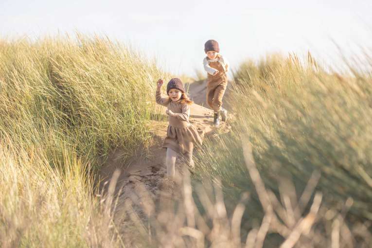 Children running through the dunes