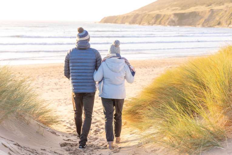 Couple walking in the winter down sandy path