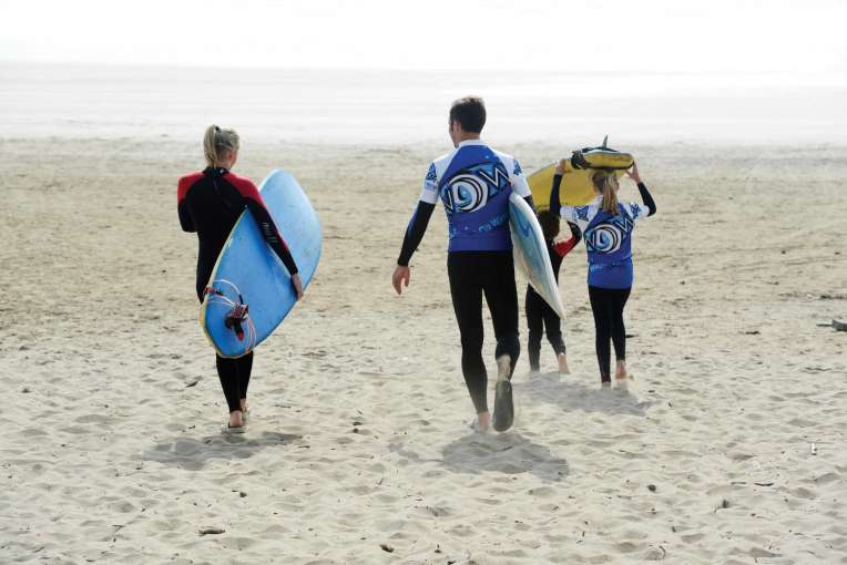 Surfing group walking to sea