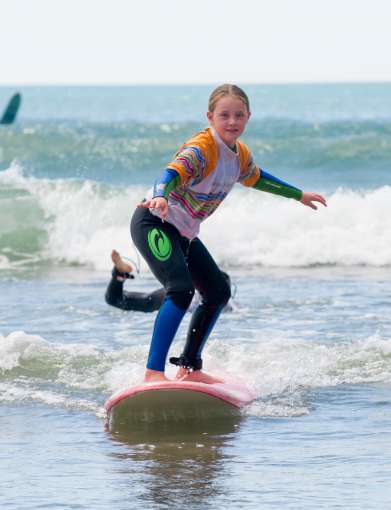 Young girl enjoying a surfing lesson on Saunton beach 