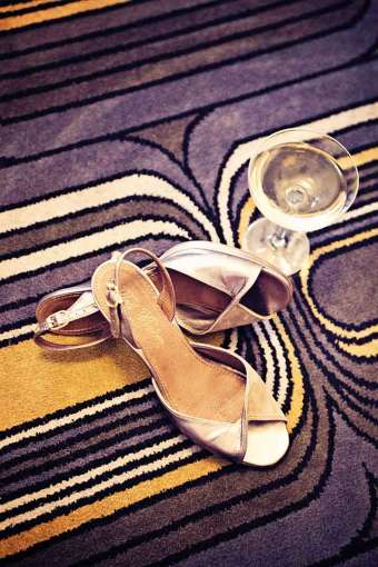 High heeled shoes on the floor with a glass of champagne 