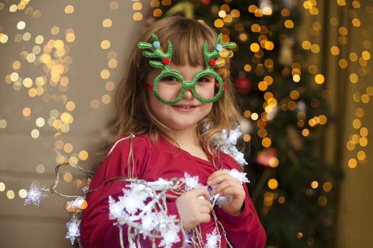 Child at a Christmas party with Christmas tree party glasses