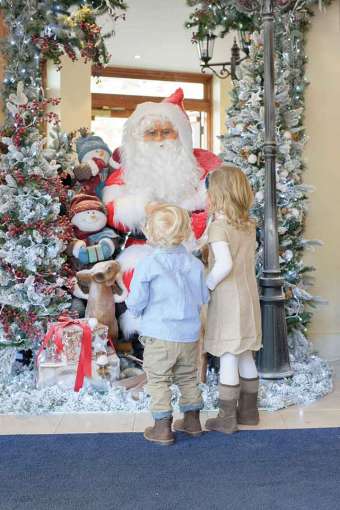 two children looking at father Christmas