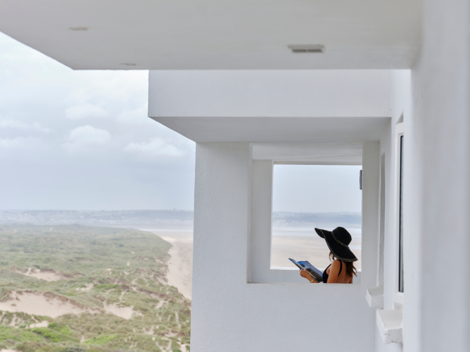 Lady reading on apartment balcony at saunton sands with view of the beach 