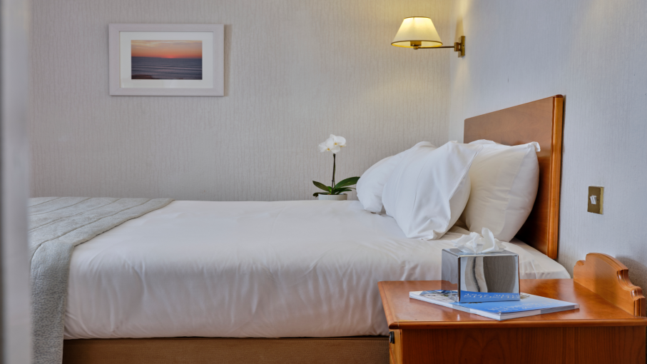 Double bed with tissues and magazine on the night stand at Saunton Sands Hotel