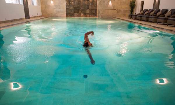 Man swimming in the indoor pool during the evening