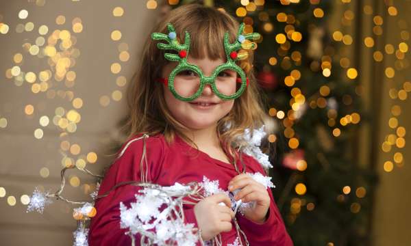 Child at a Christmas party with Christmas tree party glasses