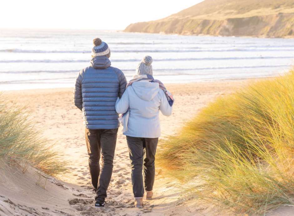 Couple walking in the winter down sandy path