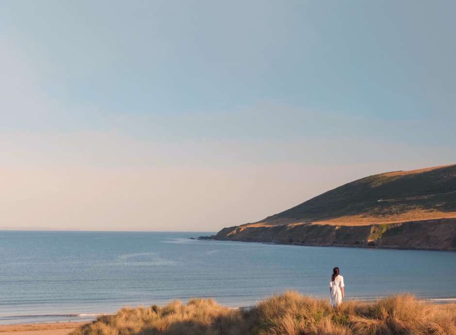 Lady on the dunes looking out to sea