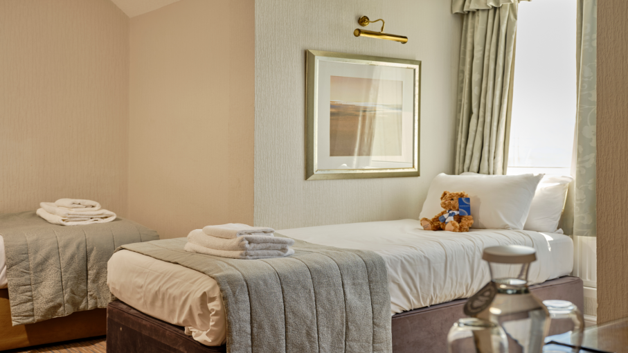 Two single beds with a teddy on the bed at Saunton Sands Hotel