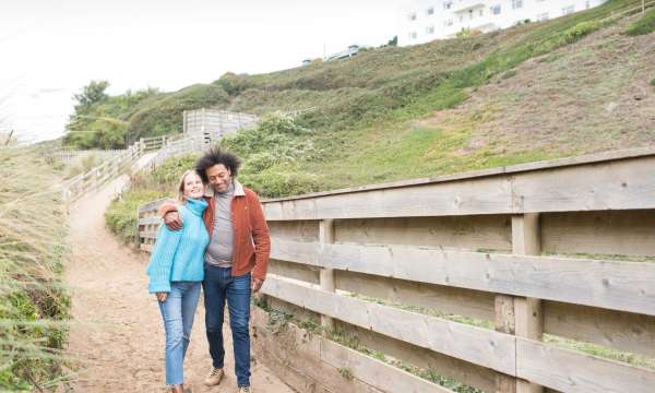 Couple walking down sandy path