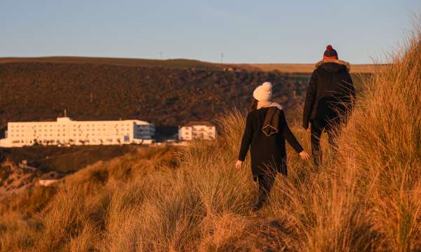 Couple walking through the dunes