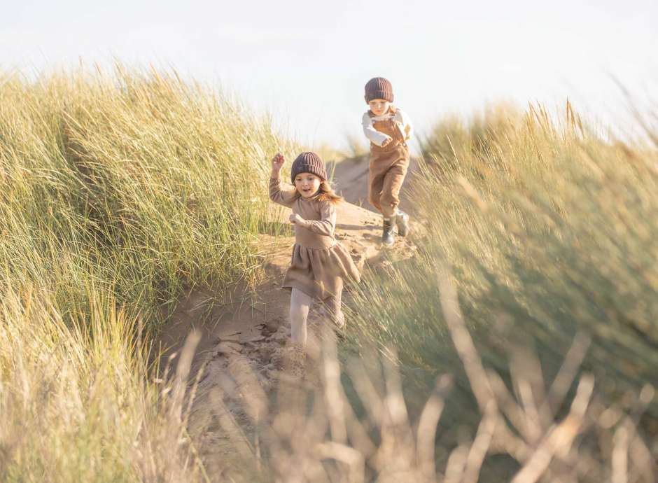 Children running through the dunes