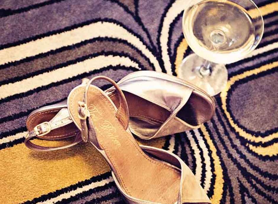 High heeled shoes on the floor with a glass of champagne 