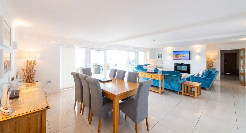 Surf lounge area with dining table, chairs and blue velvet sofas